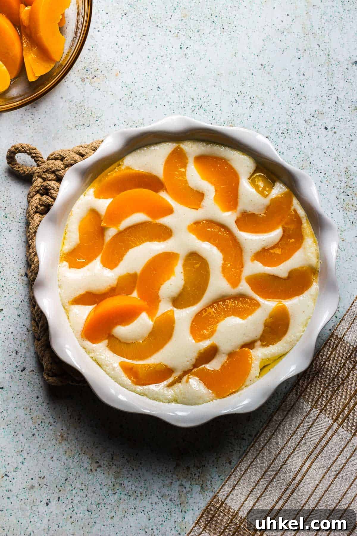 Classic Southern Peach Cobbler Recipe — Homemade & Fruity 4 unbaked peach cobbler in a baking dish