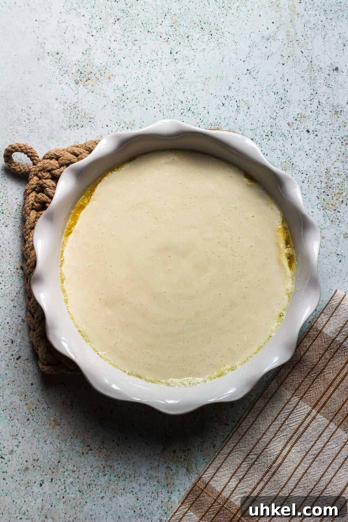 Classic Southern Peach Cobbler Recipe — Homemade & Fruity 9 pouring batter over butter