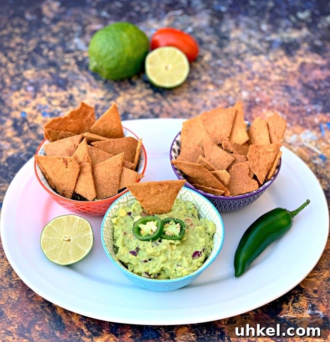 Quick Homemade Guacamole Recipe Ready in Minutes 7 keto tortilla chips in bowls on a plate with guacamole and vegetables