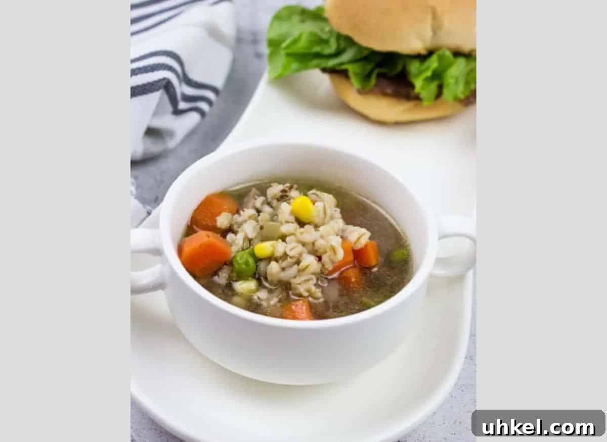 19 Budget-Friendly Dinners That Cut Your Grocery Bill (Delicious!) 11 A bowl of Beef and Barley Soup with a burger on a long white tray.