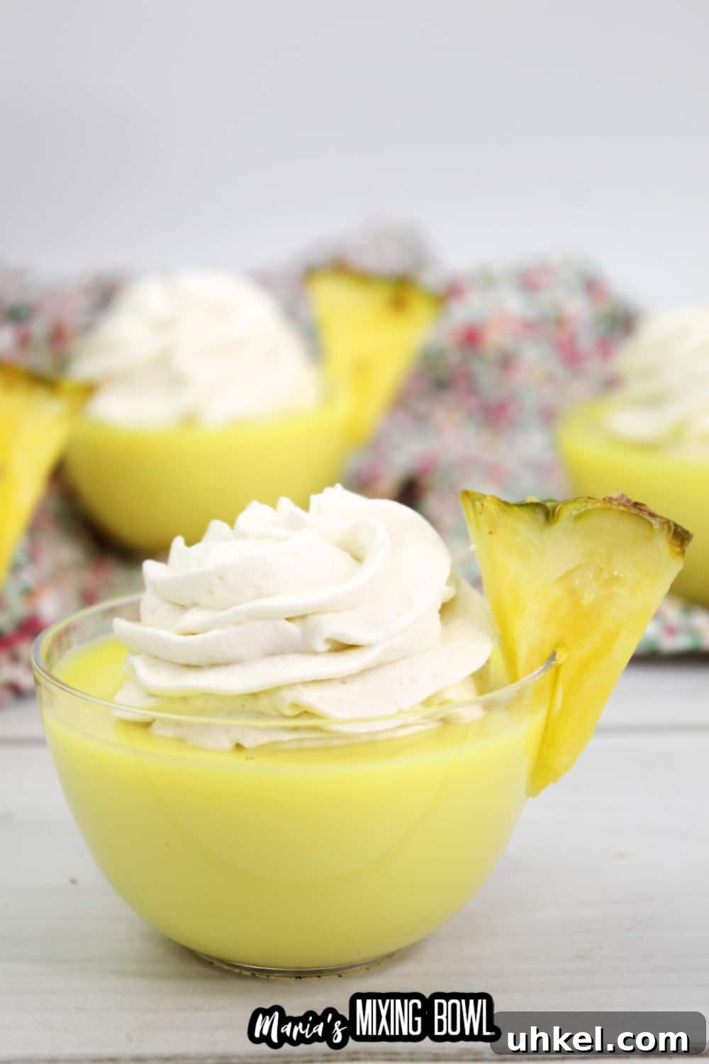 dole whip shot in a small glass bowl garnished with a slice of pineapple
