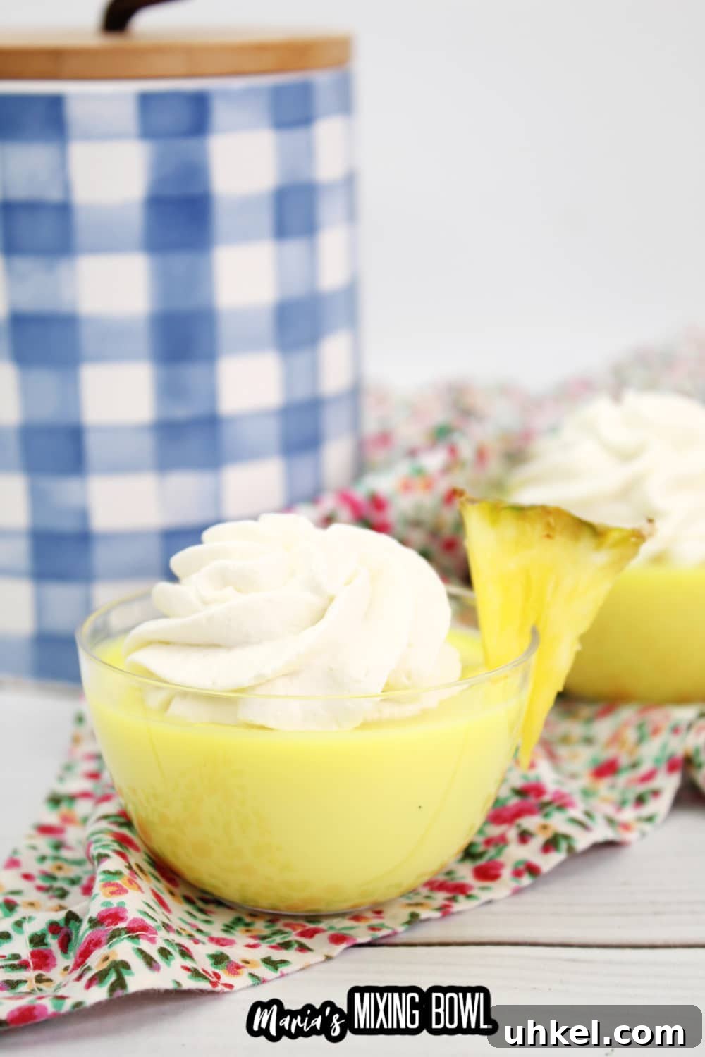 dole whip shot in a small glass bowl garnished with a slice of pineapple