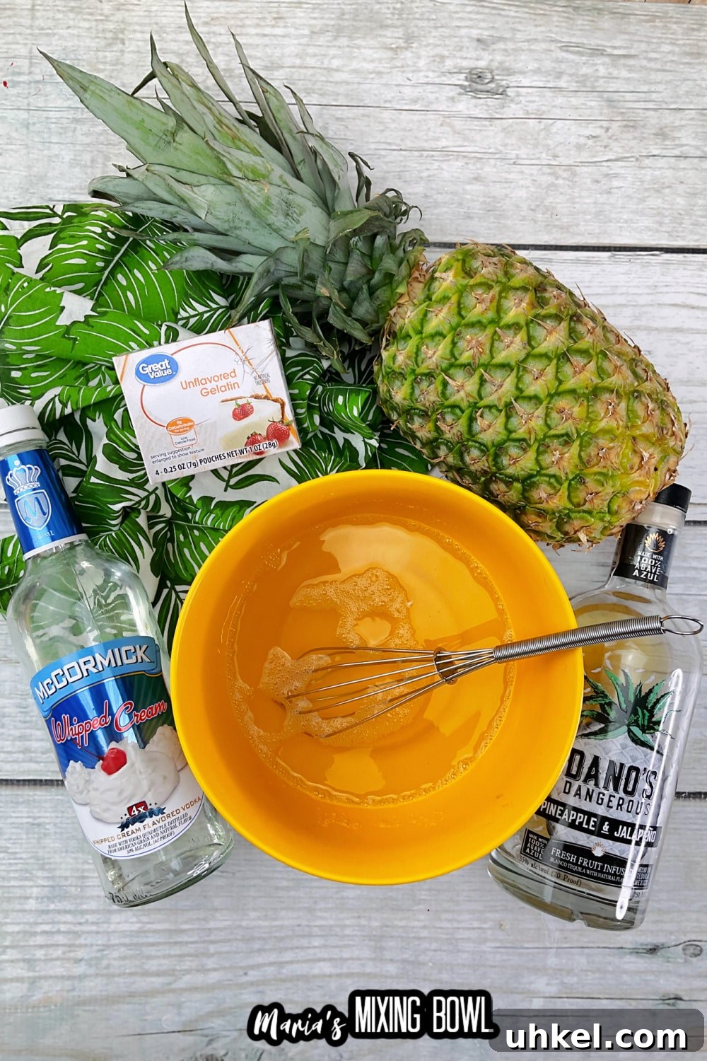 unflavored gelatin being mixed with water in an orange mixing bowl with a whisk