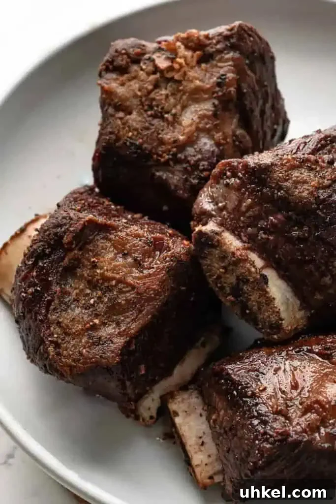 ragu short ribs Seared bone-in short ribs on a plate, highlighting the deep brown crust from searing.