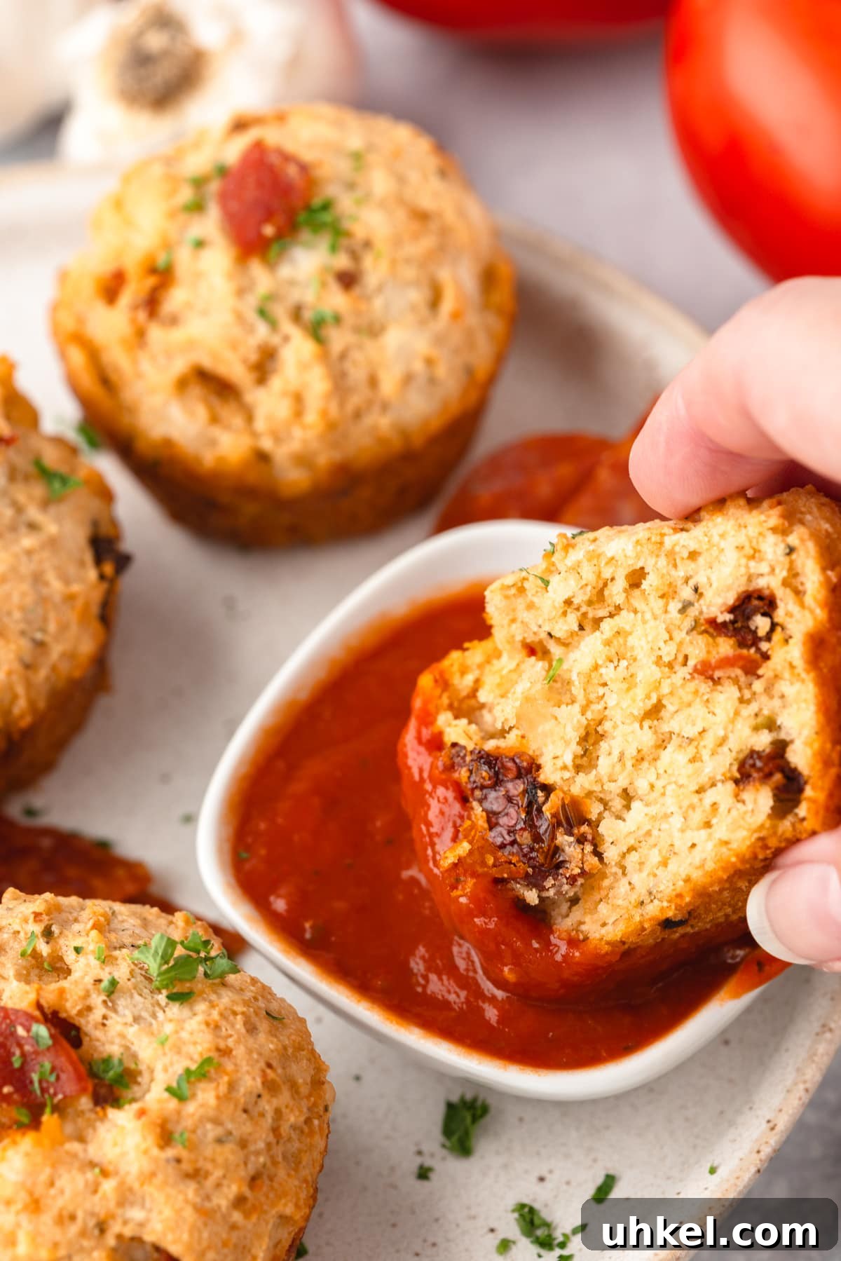 Cheesy Pizza Muffins Recipe: Savory Bite-Sized Breakfasts 3 Crunchy cornbread muffins with melted cheese and fresh herbs, served with spicy tomato dipping sauce.