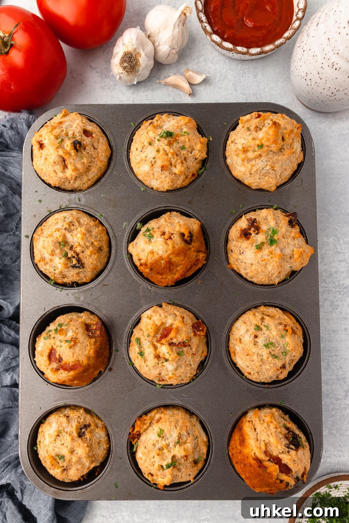 Cheesy Pizza Muffins Recipe: Savory Bite-Sized Breakfasts 6 Savory breakfast egg muffins with vegetables and cheese in muffin tin.
