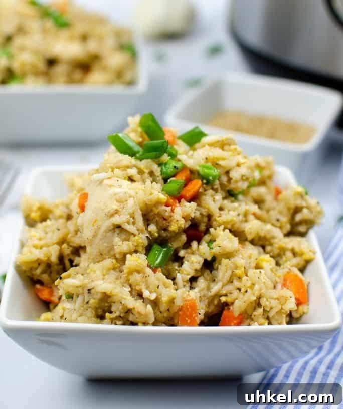 side view of a square white bowl heaped with chicken fried rice cooked in the Instant Pot