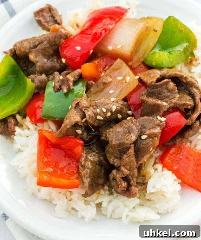 Instant Pot pepper steak served over rice on a white plate