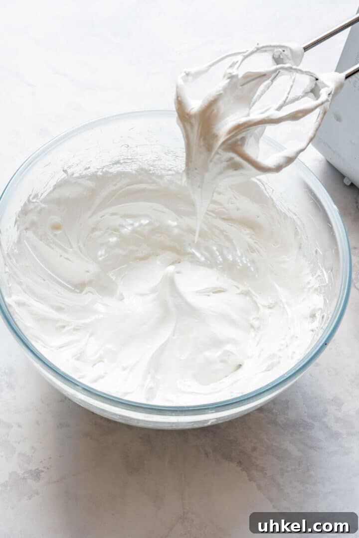 Heart-Shaped Mini Pavlovas: Valentine Dessert Recipe Ideas 6 Glossy Swiss meringue whipped to thick peaks in a mixing bowl.
