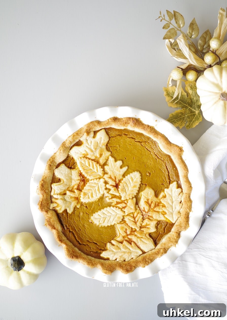 Gluten-Free Pumpkin Pie Recipe That Tastes Like Fall 3 gluten-free pumpkin pie in a white pie pan with white pumpkins and a white nampkin