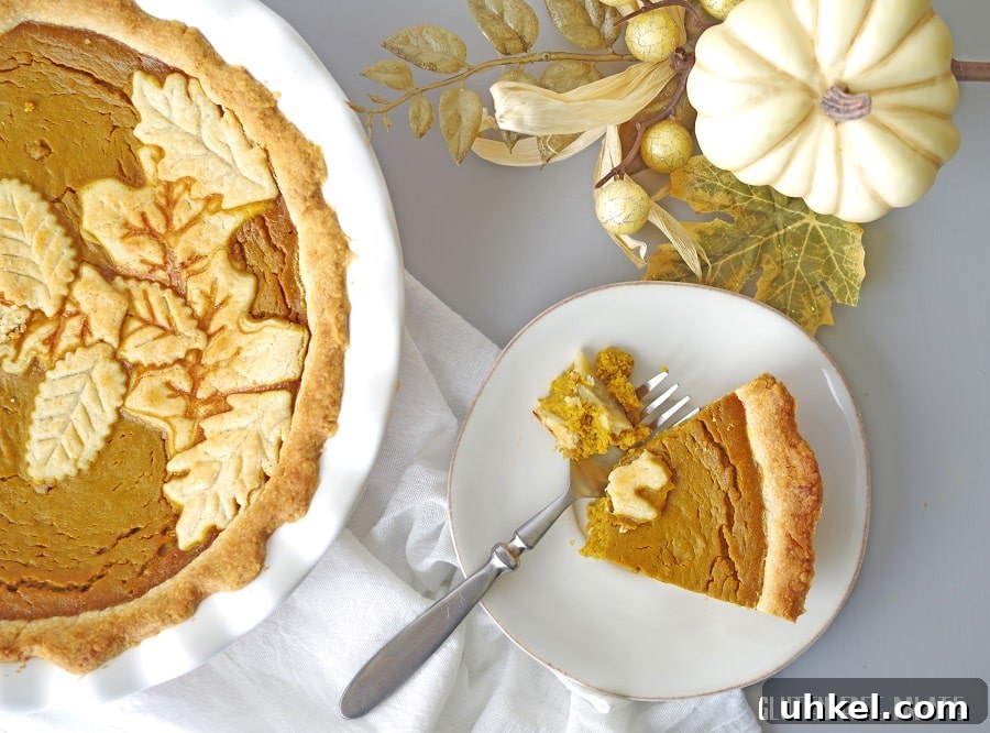 Gluten-Free Pumpkin Pie Recipe That Tastes Like Fall 4 gluten-free pumpkin pie in a white pie pan with white pumpkins and a white nampkin, next to a slice of pumpkin pie