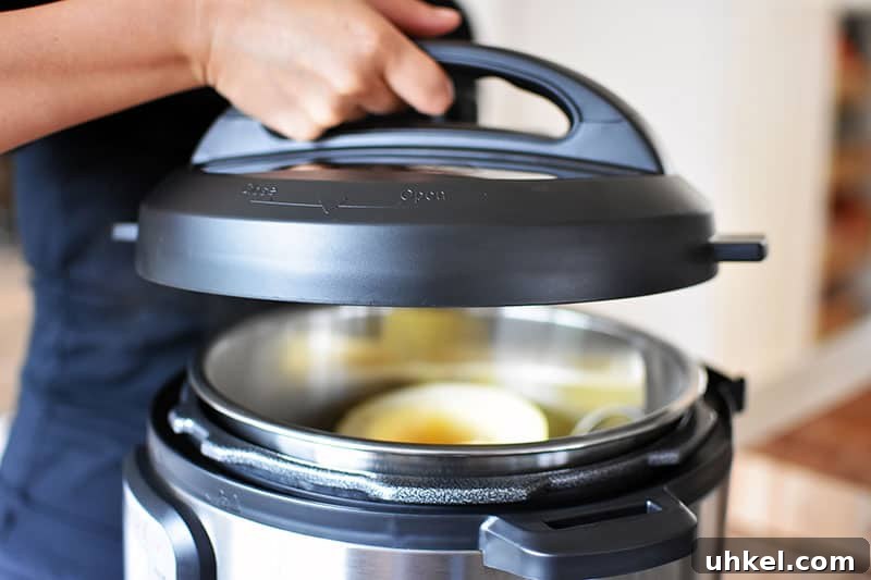 Instant Pot Spaghetti Squash — Quick Foolproof Pressure Cooker Recipe 11 A close-up of an Instant Pot lid being lowered to cover the spaghetti squash.
