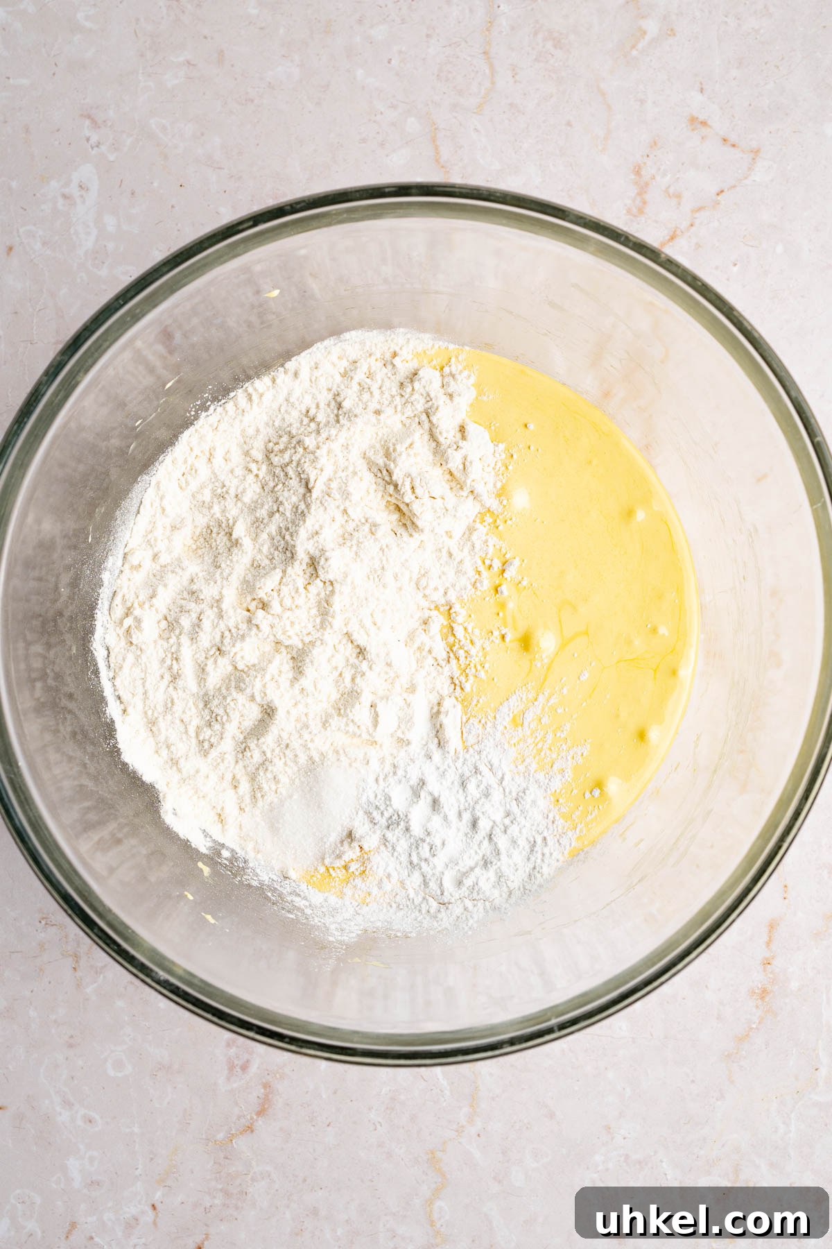 The beaten egg yolk mixture in a large glass bowl with the flour, salt, and baking powder. 
