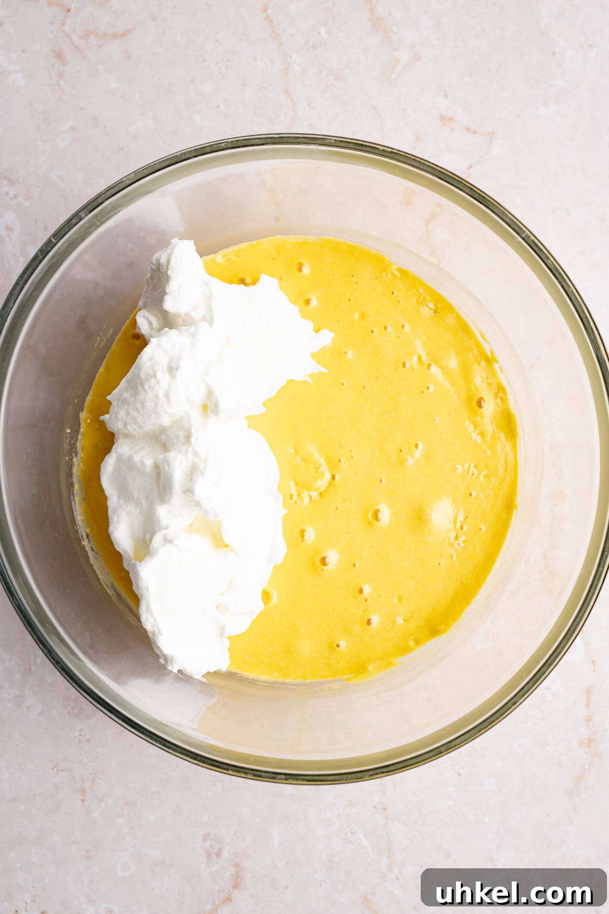 The beaten egg white mixture in the bowl with the cake mixture before stirring everything together.