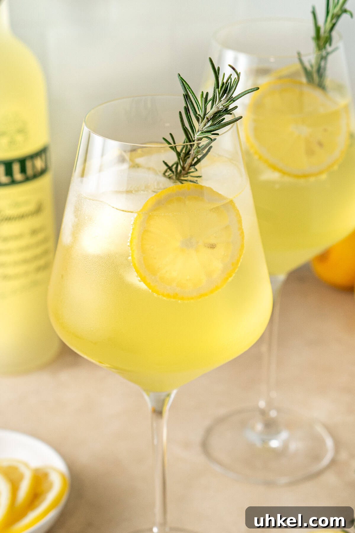 Close up of a limoncello spritz with rosemary and lemon slices. 