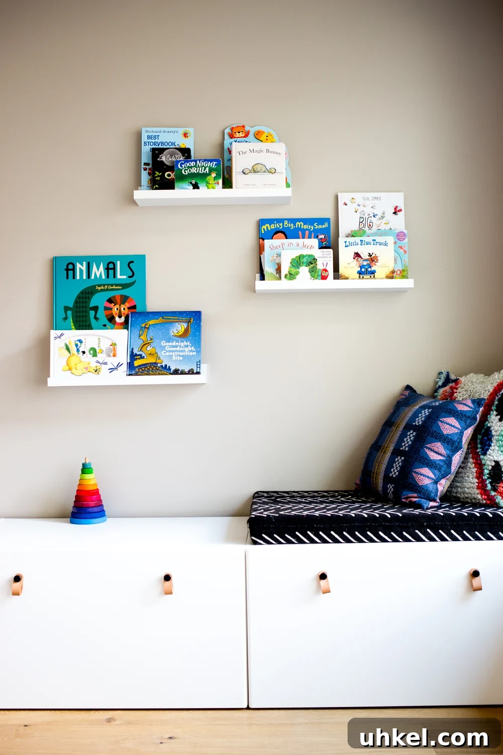 Declutter Kids' Toys: Simple Steps to Tidy Playrooms 2 modern playroom with books on floating shelves and white storage drawers with bohemian and african mudcloth style cushions