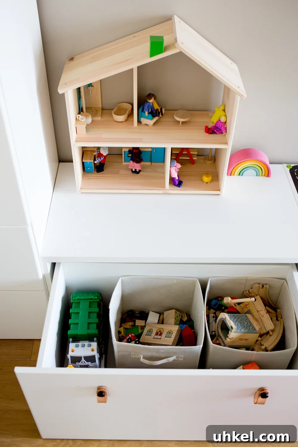 Declutter Kids' Toys: Simple Steps to Tidy Playrooms 7 white modern toy storage bench IKEA with toys in open drawer and simple wooden dollhouse on top