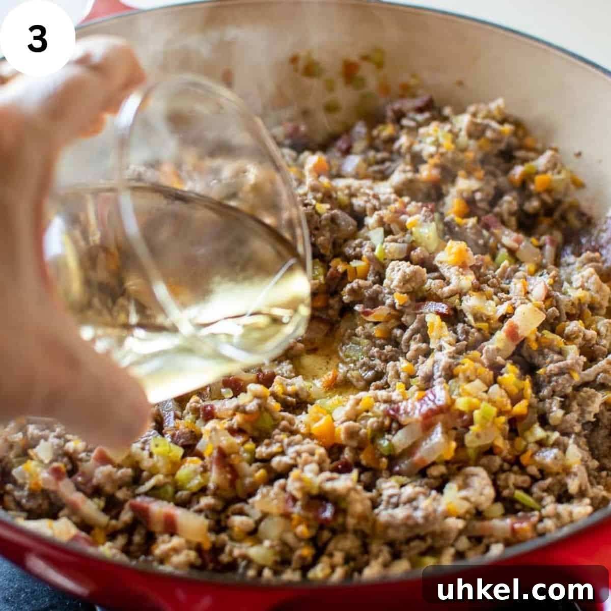 Authentic Tagliatelle alla Bolognese Recipe 6 White wine being poured into browned ground meat.