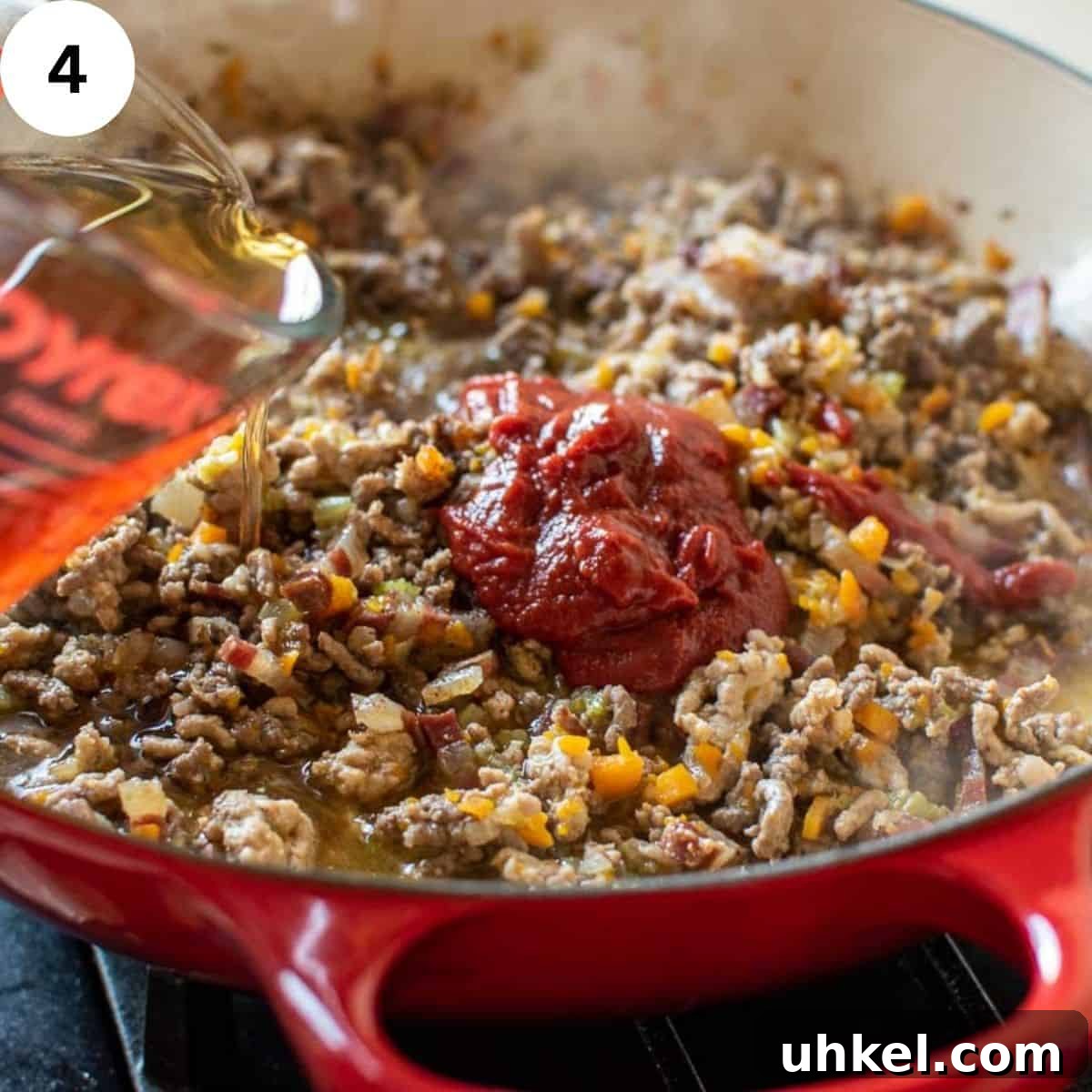 Authentic Tagliatelle alla Bolognese Recipe 7 Beef stock being added to browned ground meat.