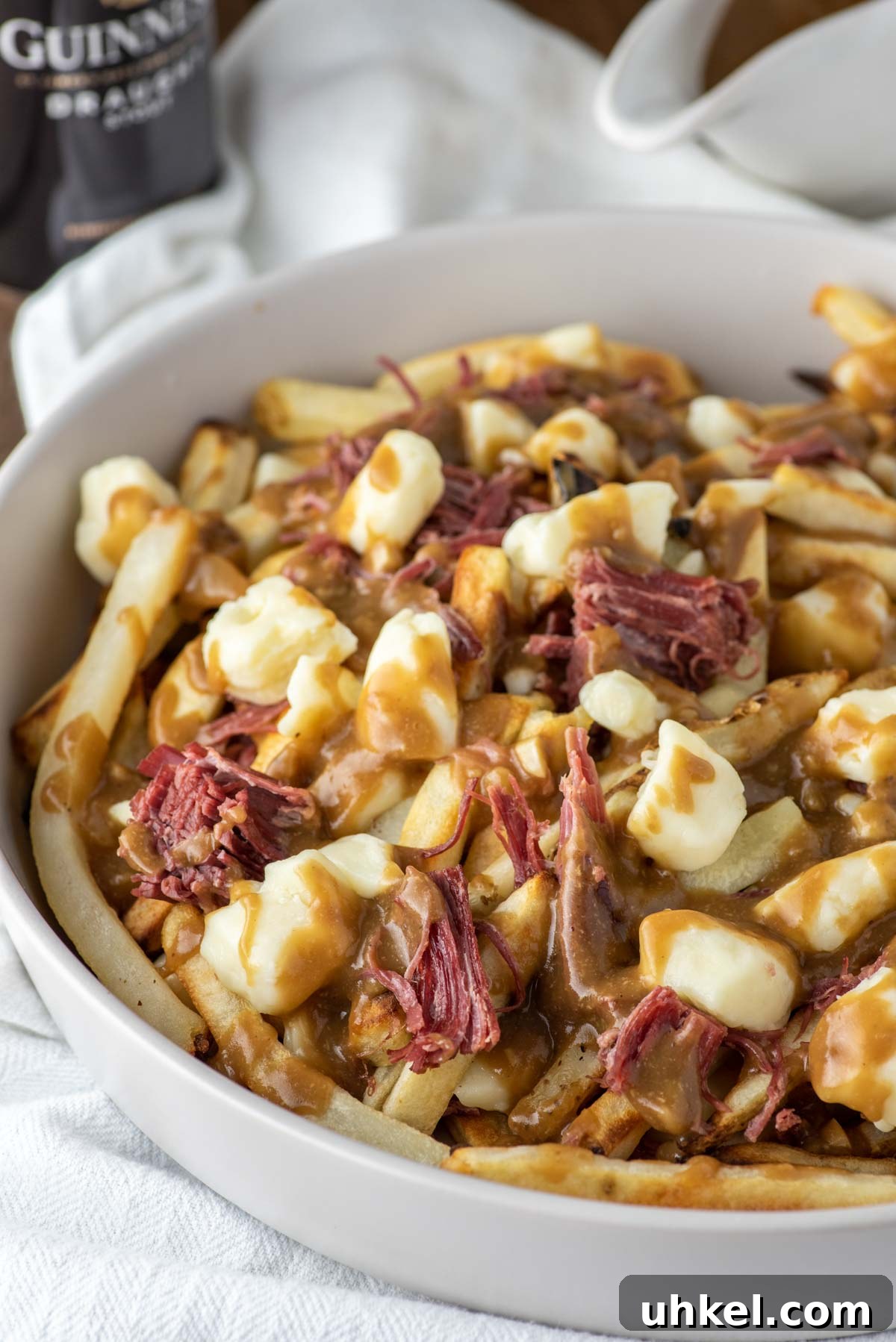 Corned Beef Poutine Topped with Guinness Gravy 3 corned beef poutine in white bowl on dish towel