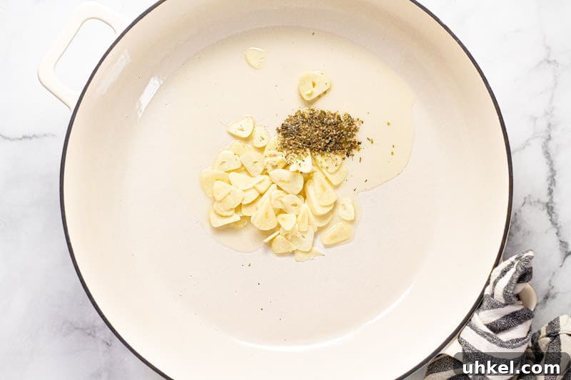 Spring Ravioli with Peas and Asparagus 5 Large white pan filled with sliced garlic dried oregano and olive oil