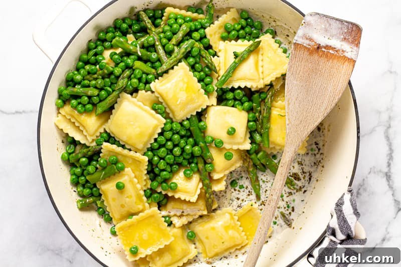 Spring Ravioli with Peas and Asparagus 6 Large white pan with a creamy herb and garlic goat cheese sauce with ravioli peas and asparagus