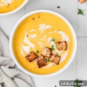 Roasted Butternut Squash and Apple Soup 14 A bowl of butternut squash soup with croutons floating on the surface.