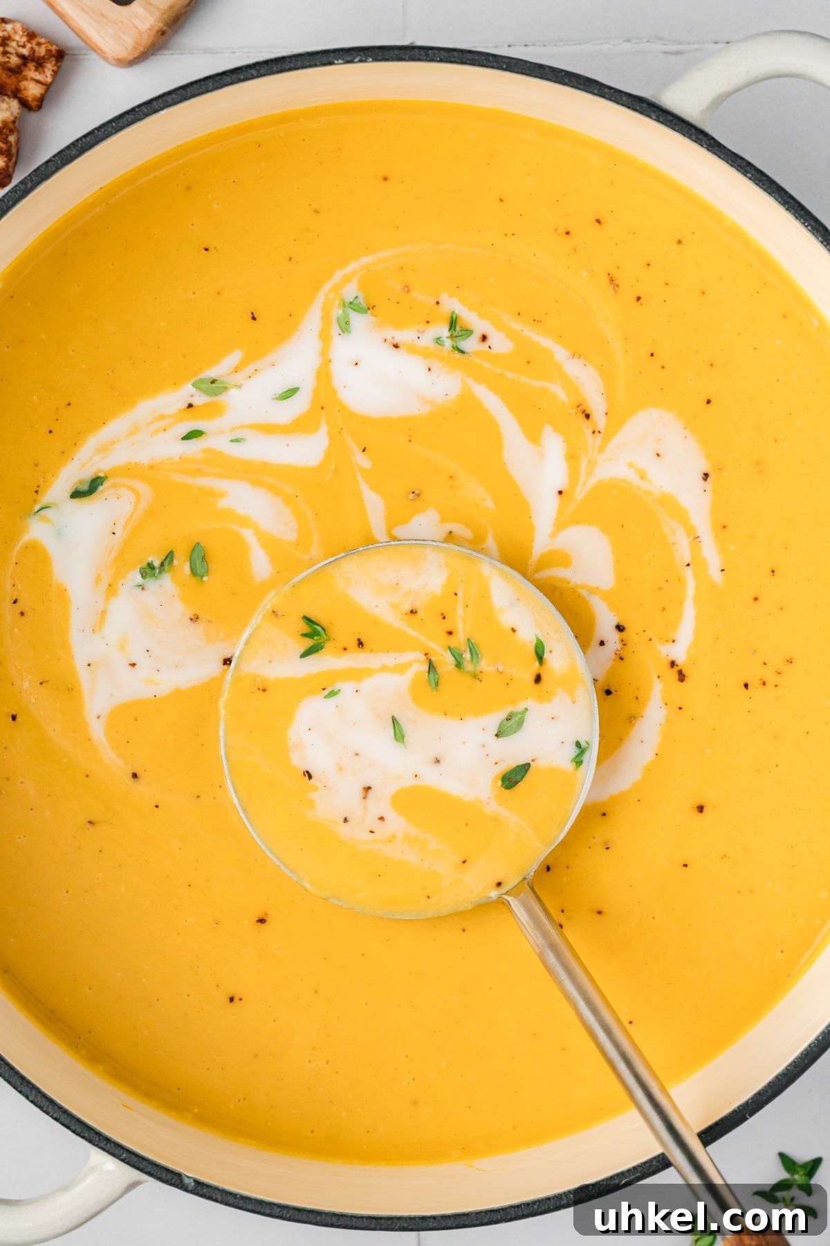 Roasted Butternut Squash and Apple Soup 7 A Dutch oven filled with butternut squash soup, with a swirl of coconut milk in the center.