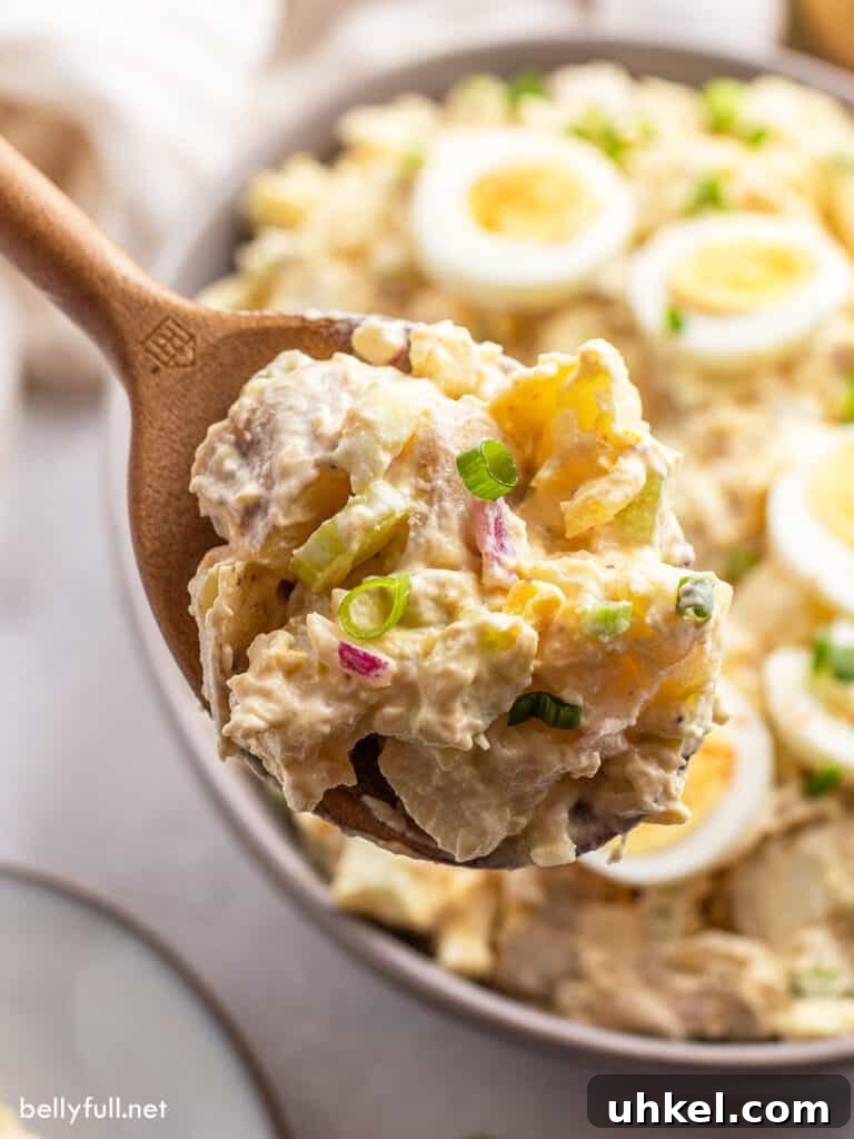 Creamy Classic Potato Salad Recipe 4 close up potato salad on wooden spoon