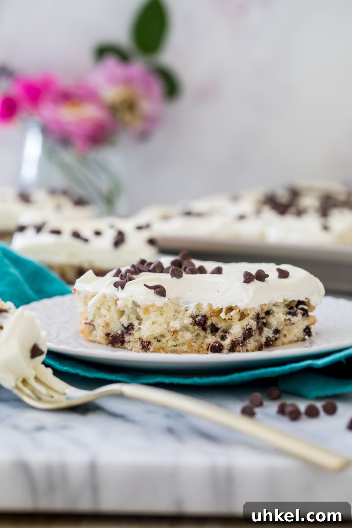 Classic Chocolate Chip Sheet Cake Recipe 6 slice of chocolate chip sheet cake on a white plate on a teal towel