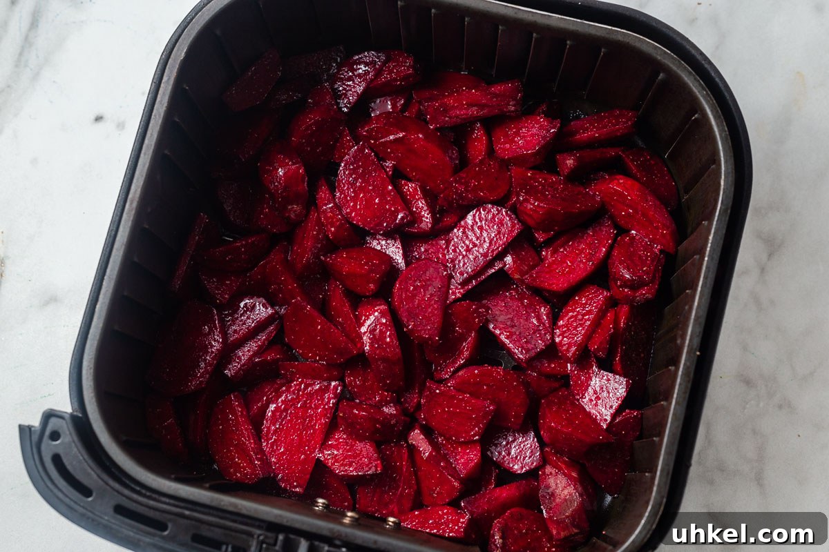 Air Fryer Roasted Beets with Crispy Edges 6 sliced and seasoned beets in the air fryer.